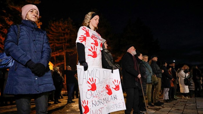 A person holds a placard during a silent protest next to a place of mass shooting, Cetinje, Montenegro, January 5, 2025. REUTERS/Stevo Vasiljevic