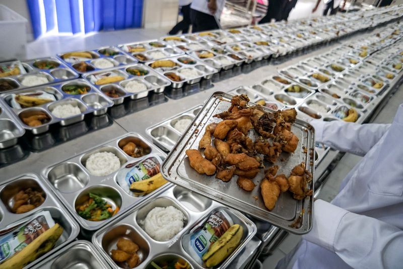 Petugas dapur menyiapkan menu makan siang untuk didistribusikan ke sekolah-sekolah pada Program Makan Bergizi Gratis (MBG) oleh Satuan Pelayanan Pemenuhan Gizi (SPPG) di Lanud Adi Soemarmo, Karanganyar, Jawa Tengah, Senin (6/1/2025). Pemerintah mulai hari ini mengoperasikan 190 satuan pemenuhan pelayanan gizi (SPPG) atau dapur MPG yang tersebar di 26 provinsi dan berharap target 937 dapur MBG dapat tercapai pada akhir Januari 2025. ANTARA FOTO/Mohammad Ayudha/nz.