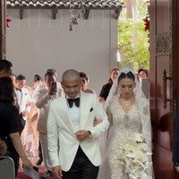 Frank dan Winona tampil kompak mengenakan busana pengantin berwarna putih. Frank tampak memadukan jas putih dengan celana panjang dan dasi kupu-kupu berwarna hitam. Sementara Winona tampil elegan dan menawan berbalut kebaya brukat lengan panjang dipadukan veil berekor. Foto: Instagram/@hotmanparisofficial