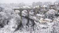 Salju menutupi rumah-rumah dan Jembatan Knaresborough di Knaresborough, Inggris, pada Minggu (5/1). AP/Danny Lawson
