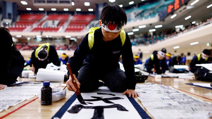 Participants take part in a New Year calligraphy contest at Nippon Budokan in Tokyo, Japan, January 5, 2025. REUTERS/Issei Kato