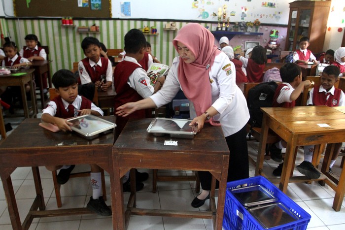 Guru membagikan  paket makanan kepada siswa dalam pelaksanaan Program Makan Bergizi Gratis (MBG) di SDN 1 Tamanharjo, Singosari, Malang, Jawa Timur, Senin (6/1/2025). Pelaksanaan perdana Program  Makan Bergizi Gratis (MBG) perdana tersebut dilaksanakan pihak TNI AU dengan menyasar 27 sekolah di sekitar kawasan Lanud Abdul Rahman Saleh dengan jumlah 4.005 porsi per hari. ANTARA FOTO/Ari Bowo Sucipto