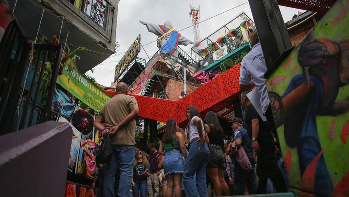 People pose for a photo during their visit to Cristo Redentor Paisa, the largest monument in Latin America created with 3D printing, located in Comuna 13 in Medellin, Colombia January 2, 2025. REUTERS/Juan David Duque