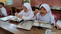 Sejumlah siswi di SD Negeri Larangan 1 Kecamatan Candi, Sidoarjo sedang menikmati makan bergizi gratis.