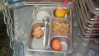 Terlihat menu MBG ini dilengkapi sepotong ayam goreng, tumisan sayur, telur rebus, dan sebutir jeruk. Foto: Facebook Hendy Cakra Pangandaran