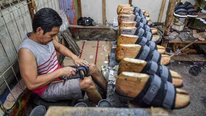 Denyut Sentra Produksi Sepatu Cibaduyut Pekerja membentuk dampalan sesuai dengan ukuran saat memproduksi sepatu di sentra produksi sepatu Cibaduyut, Bandung, Jawa Barat, Selasa (7/1/2025). Asosiasi Persepatuan Indonesia (Aprisindo) menyatakan, pelemahan nilai tukar rupiah terhadap dollar AS dalam beberapa waktu terakhir berpotensi ikut mendongkrak biaya produksi industri alas kaki nasional sebanyak dua persen sedangkan kebutuhan bahan baku yang harus dipenuhi dari impor untuk produksi alas kaki mencapai 50 persen. ANTARA FOTO/Raisan Al Farisi/YU