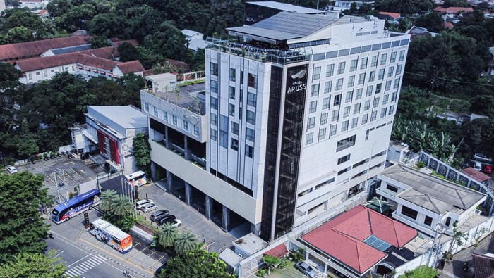Penampakan Hotel Aruss Semarang yang Disita Terkait Judol Foto udara sejumlah kendaraan terparkir di halaman gedung Hotel Aruss Semarang yang masih beroperasi usai disita Bareskrim Mabes Polri di Semarang, Jawa Tengah, Selasa (7/1/2025). Polri menyita Hotel Aruss yang ditaksir bernilai Rp200 miliar tersebut karena diduga dibangun dari uang hasil judi daring atau tindak pidana kejahatan pencucian uang (TPPU). ANTARA FOTO/Makna Zaezar/Spt.