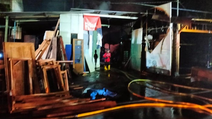 Petugas saat memadamkan api di dua bangunan yang terbakar di Jalan Wates, Kasihan, Bantul, Selasa (7/1/2025) malam.