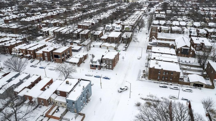 A pickup truck navigates snow-covered streets following a winter storm Monday, Jan. 6, 2025, in St. Louis. (AP Photo/Jeff Roberson)