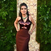 Gaun berpotongan dada rendah ini menonjolkan lekuk tubuhnya dan menjuntai elegan dengan ekor dramatis. Foto: Michael Buckner/GG2025/Penske Media via Getty Images