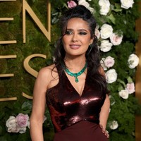 Salma Hayek berjalan di red carpet Golden Globes 2024 mengenakan gaun merah marun berlapis sequin berkilauan.  Foto: Matt Winkelmeyer/WireImage
