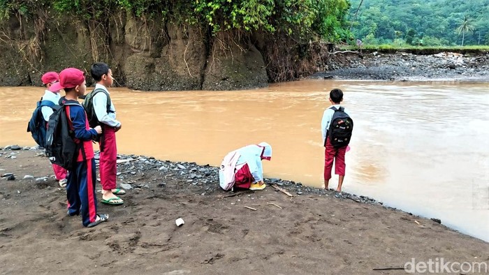 Sejumlah warga hingga pelajar kembali berjibaku melawan arus sungai Sejumlah warga hingga pelajar kembali berjibaku melawan arus sungai