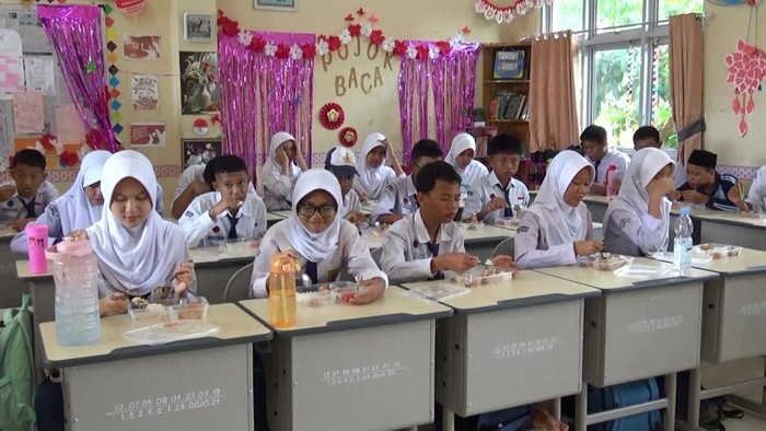 Siswa di SMP Negeri 19 Palembang menikmati makanan gratis di hari kedua