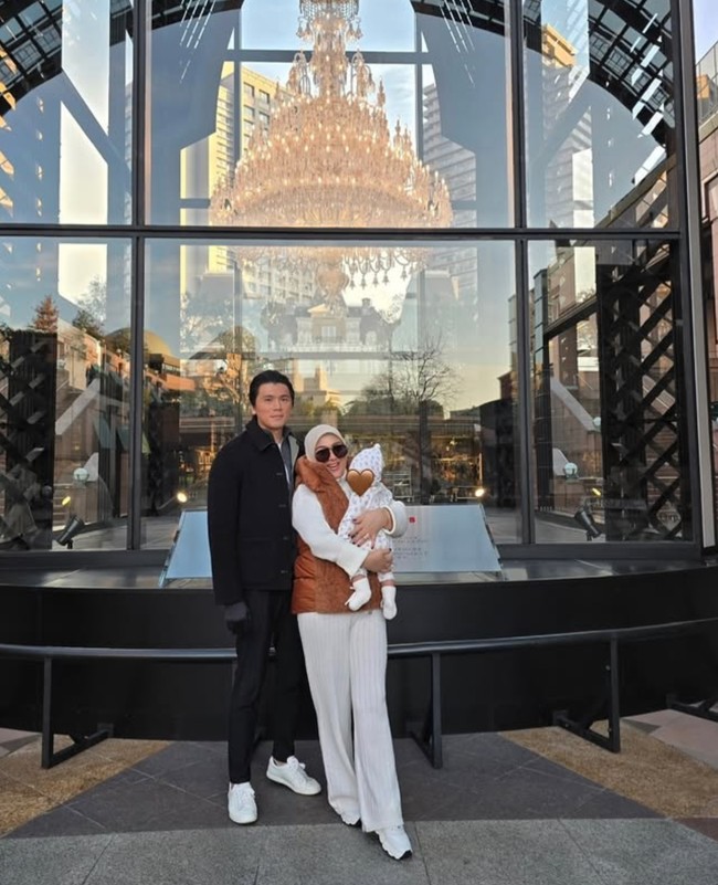 Sambil momong putri kecilnya, Syahrini tampak bahagia, begitu pula halnya dengan Reino Barack. Sayangnya hingga kini wajah baby R masih dirahasiakan dengan ditutupi stiker. Foto: Instagram/@princessyahrini