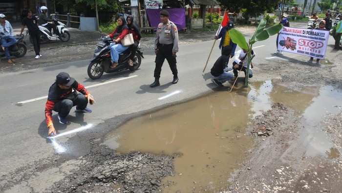 Aksi protes jalan rusak di Jember Warga menanam pohon pisang dan memberi tanda pada jalan provinsi yang rusak di Kecamatan Kencong, Jember, Jawa Timur, Rabu (8/1/2025). Aksi penanaman pohon pisang sejauh 10 kilometer di jalan Jember-Lumajang itu sebagai bentuk protes warga karena rusaknya jalan antar kabupaten akibat dilewati truk over dimension overload (ODOL/dimensi dan muatan berlebih). ANTARA FOTO/Seno/tom.