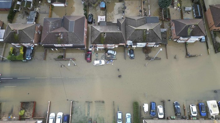 Firemen help residents in the flooded area of Barrow Upon Soar, England, Tuesday, Jan. 7, 2025.(AP Photo/Darren Staples)