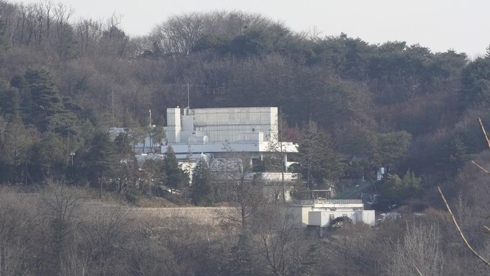 Deretan Bus Halangi Gerbang Masuk Kediaman Presiden Korsel Yoon Suk Yeol Security personnel walk on a road lined up with buses blocking the entrance gate of impeached South Korean president Yoon Suk Yeol's residence in Seoul, South Korea, Wednesday, Jan. 8, 2025. (AP Photo/Ahn Young-joon)