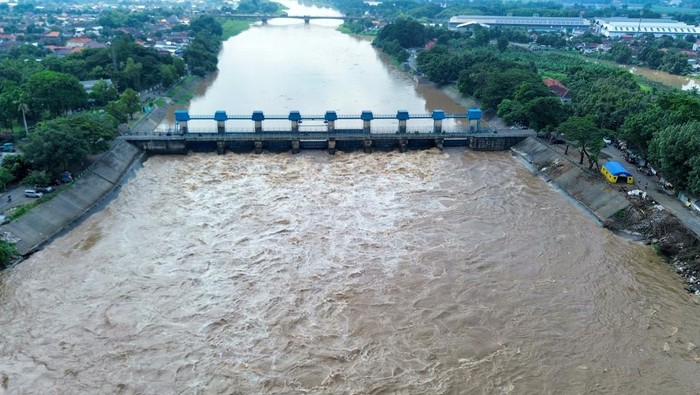Foto udara jalan Raya Mliriprowo ambrol tergerus air sungai di Bendungan Rolak Songo, Desa Mliriprowo, Tarik, Sidoarjo, Jawa Timur, Selasa (7/1/2025). Intensitas hujan tinggi dalam beberapa hari terakhir membuat debit air Sungai Brantas di pintu dam Rolak Songo mengalami peningkatan, mengakibatkan jalan Raya Mliriprowo ambrol tergerus air sungai. ANTARA FOTO/Umarul Faruq/Spt.