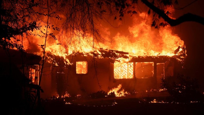 Kebakaran Hutan di California Hangusnya Rumah hingga Restoran Flames rise from a structure as the Eaton Fire burns in Pasadena, California, U.S. January 8, 2025. REUTERS/Mario Anzuoni