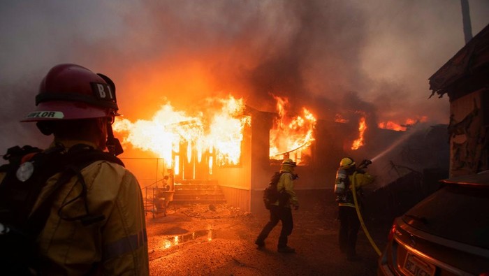 Firefighters work to extinguish the fire as the Palisades Fire burns during a windstorm on the west side of Los Angeles, California, U.S. January 7, 2025. REUTERS/Ringo Chiu