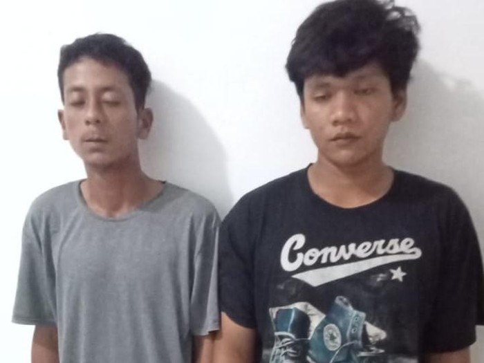 Kedua pelaku saat diamankan di kantor polisi.