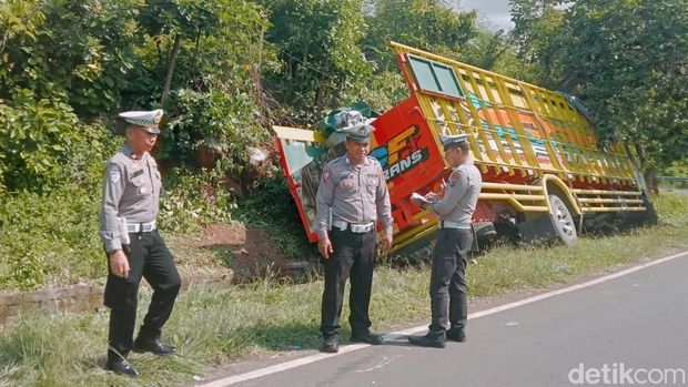 Polisi melakukan olah TKP terkait kecelakaan truk ekspedisi yang terperosok ke got saat hendak melalui jalan menurun di Desa Lewolaga, Kecamatan Titehena, Kabupaten Flores Timur, NTT, Rabu (8/1/2025). (Foto: Yurgo Purab/detikBali)