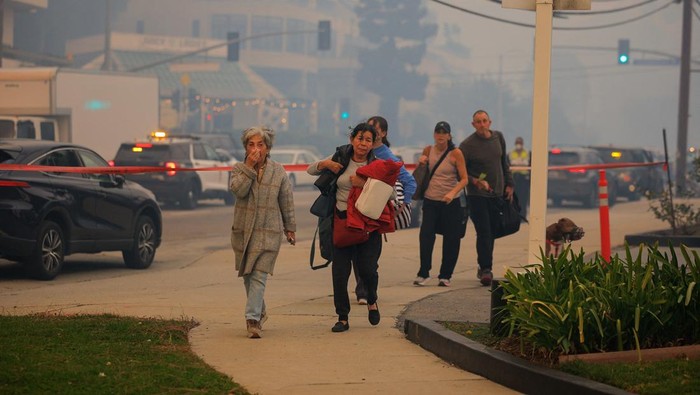 Puluhan Ribu Orang di Los Angeles Dievakuasi Akibat Kebakaran Hutan People evacuate, as a wildfire breaks-out near Pacific Palisades on the west side of Los Angeles during a weather driven windstorm in Southern California, January 7, 2025. REUTERS/Mike Blake