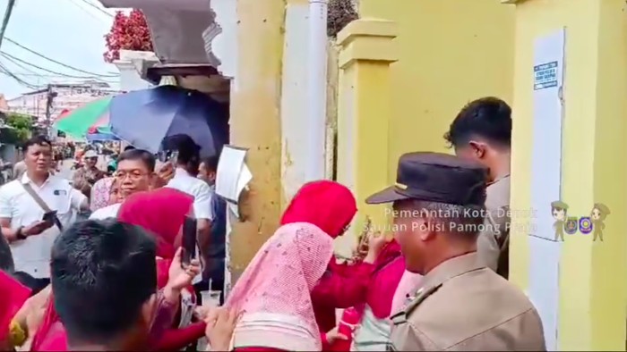 Siswa dan guru dapat masuk ke SDN Utan jaya setelah dibukanya palang kayu yang menutup akses ke sekolah (dok Satpol PP Depok)