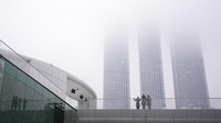 Pemandangan kabut tebal yang menyelimuti gedung-gedung pencakar langit menjadi sorotan warga sekitar.  