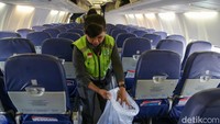 Di sisi lain, petugas kebersihan dan awak kabin juga mulai membersihkan pesawat setelah mendarat. Mulai dari memilah sampah, merapikan kantong yang ada di bangku pesawat, memeriksa kelengkapan.