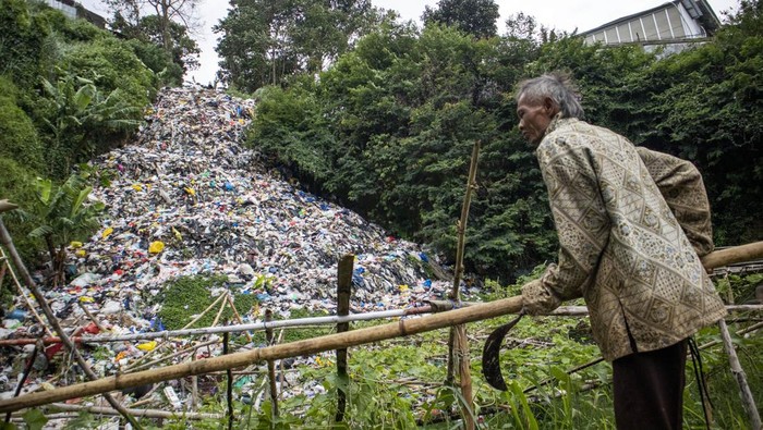 Warga memperbaiki kayu penyangga tanaman di dekat tempat pembuangan sampah (TPS) ilegal di Gudangkahuripan, Lembang, Kabupaten Bandung Barat, Jawa Barat, Rabu (8/1/2025). Warga setempat mengeluhkan keberadaan TPS yang diduga tidak memiliki izin tersebut karena menimbulkan aroma tidak sedap dan mencemari lingkungan sekitar. ANTARA FOTO/Abdan Syakura/rwa.
