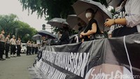 Sejumlah pegiat HAM berdiri tegak saat aksi Kamisan ke-846 di depan Istana Merdeka, Jakarta.