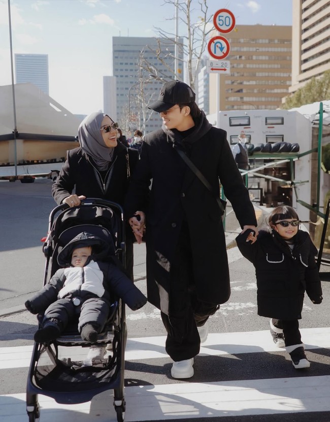 Tampil kompak bersama anak dan suaminya, keluarga Atta dan Aurel itu tampak mengenakan busana yang didominasi warna hitam. Aurel memilih memadukan busana hitamnya tersebut dengan hijab abu-abu dan sepasang sneakers berwarna putih. Foto: Instagram/@aurelie.hermansyah