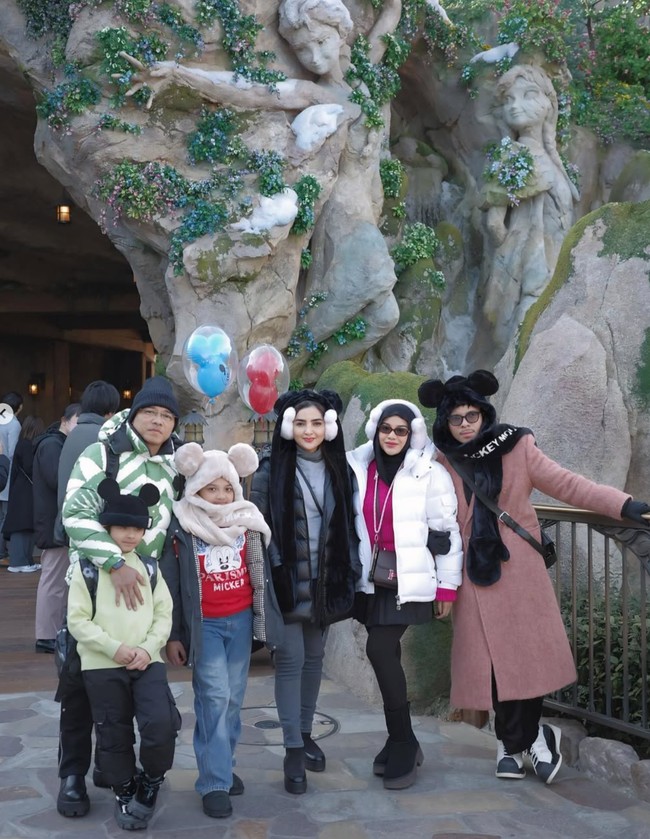 Penampilan yang satu ini juga terlihat saat Aurel berkunjung ke Tokyo DisneySea. Ia tampak memadukan sweater pink dengan jaket parka berwarna putih, legging hitam, dan rok mini yang juga berwarna hitam. Ia kemudian melengkapi penampilannya dengan penutup telinga berbentuk kepala Mickey berwarna putih. Foto: Instagram/@aurelie.hermansyah