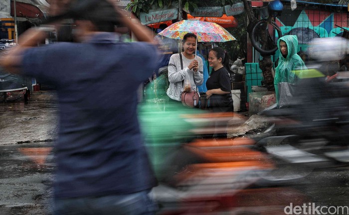 Hujan mengguyur wilayah Jakarta sejak pagi tadi, Kamis (9/1/2025). Warga tetap beraktivitas meski hujan mengguyur.