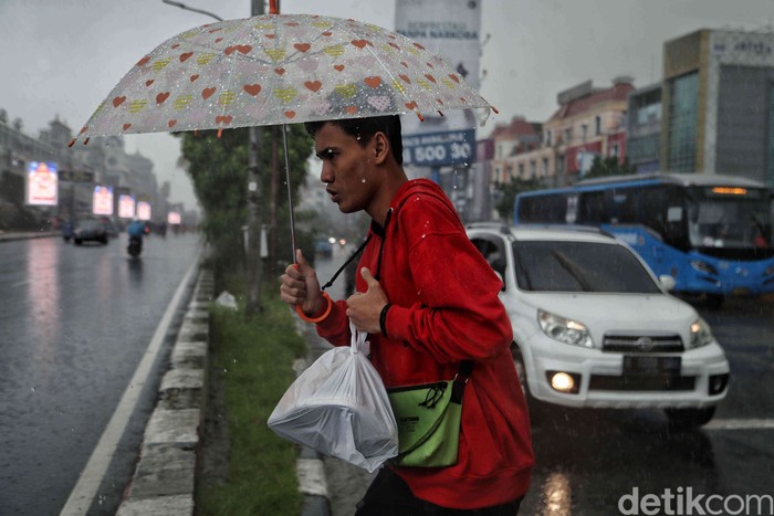 Hujan mengguyur wilayah Jakarta sejak pagi tadi, Kamis (9/1/2025). Warga tetap beraktivitas meski hujan mengguyur.