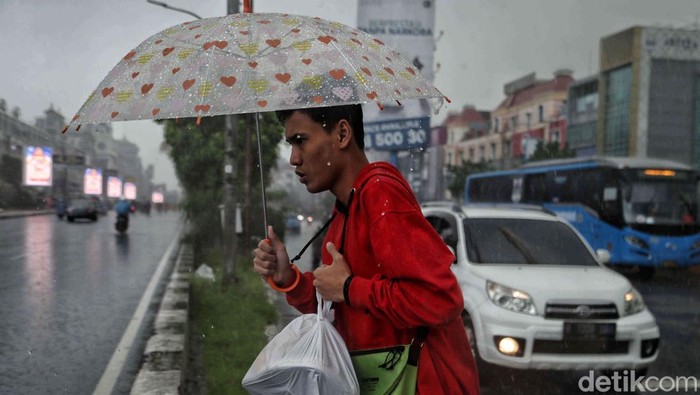 Hujan mengguyur wilayah Jakarta sejak pagi tadi, Kamis (9/1/2025). Warga tetap beraktivitas meski hujan mengguyur.