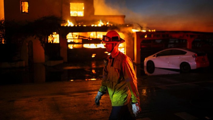 Kebakaran Hutan di AS Merembet ke Rumah, 5 Orang Tewas A destroyed car stands amid the rubble of a burnt home as powerful winds fueling devastating wildfires in the Los Angeles area force people to evacuate, in the Pacific Palisades neighborhood of west Los Angeles, California, U.S. January 8, 2025. REUTERS/Mike Blake