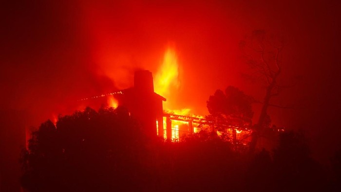 Malam Mencekam, Langit California Memerah gegara Kebakaran Hutan A building burns during the Palisades Fire in the Pacific Palisades neighborhood of west Los Angeles, California, January 7, 2025. REUTERS/Mike Blake