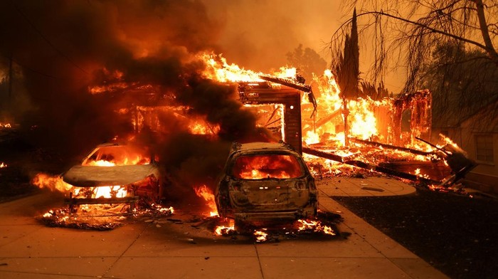 Vehicles and a house burn as powerful winds fueling devastating wildfires in the Los Angeles area force people to evacuate, at the Eaton Fire in Altadena, California, U.S. January 8, 2025. REUTERS/David Swanson