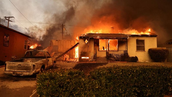 Mobil-mobil Hangus Terbakar Saat Kebakaran Hutan Landa California A house burns as powerful winds fueling devastating wildfires in the Los Angeles area force people to evacuate, at the Eaton Fire in Altadena, California, U.S. January 8, 2025. REUTERS/David Swanson TPX IMAGES OF THE DAY