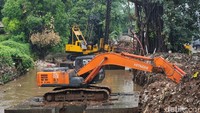 Sejumlah pekerja dan alat berat merampungkan proyek normalisasi dan jacking di area bantaran Sungai Pesanggrahan, di samping ITC Cipulir Mas, Jakarta Selatan, Kamis (9/1/2025).  
