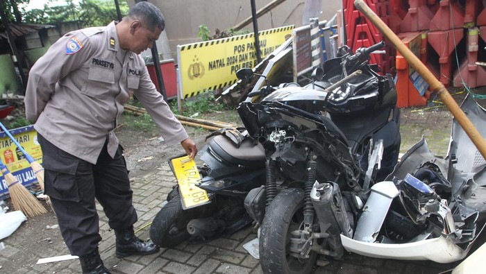 Polisi melihat bangkai kendaraan roda dua yang ringsek usai terlibat kecelakaan beruntun di Kota Batu, Jawa Timur, Kamis (9/1/2025). Kecelakaan beruntun yang terjadi pada Rabu (8/1) malam tersebut melibatkan satu unit bus pariwisata, enam unit mobil dan sepuluh sepeda motor serta mengakibatkan empat orag meninggal dunia sementara puluhan orang luka-luka. ANTARA FOTO/Ari Bowo Sucipto/foc.