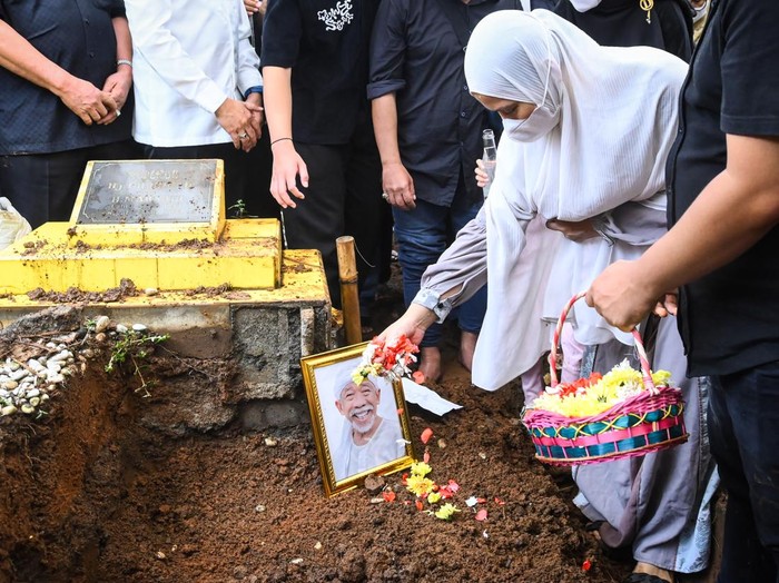 Istri pelawak sekaligus politikus Nurul Qomar, Siti Maryam (tengah) membawa bingkai foto dan berdoa saat pemakaman di TPU Carang Pulang, Pagedangan, Kabupaten Tangerang, Banten, Kamis (9/1/2025). Nurul Qomar meninggal dunia usai menjalani perawatan di RSUD Kabupaten Tangerang pada Rabu (8/1/2025). ANTARA FOTO/Sulthony Hasanuddin/foc.