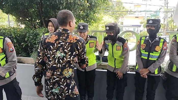 Bupati terpilih Wahono menyalami petugas yang siaga menjaga keamanan rapat pleno KPU Bojonegoro