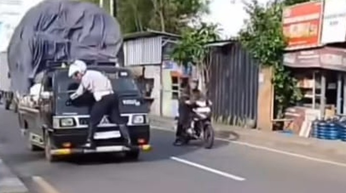 Petugas Dishub Depok nemplok di mobil pikap yang kelebihan muatan di Jalan Raya Bogor.