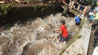 Sejumlah relawan membersihkan material batu dan kayu dampak banjir bandang yang menyumbat aliran sungai di Desa Gunungsari, Maesan, Bondowoso, Jawa Timur, Jumat (10/1/2025). 