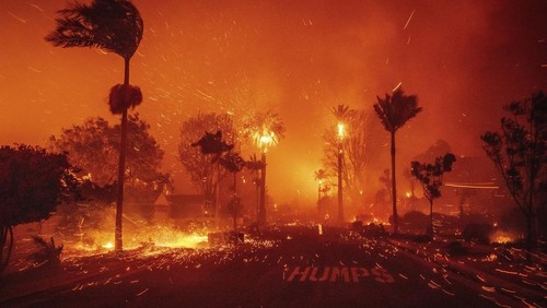 The Palisades Fire ravages a neighborhood amid high winds in the Pacific Palisades neighborhood of Los Angeles, Tuesday, Jan. 7, 2025. (AP Photo/Ethan Swope)
