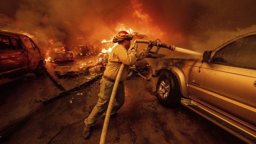 The Palisades Fire ravages a neighborhood amid high winds in the Pacific Palisades neighborhood of Los Angeles, Tuesday, Jan. 7, 2025. (AP Photo/Ethan Swope)