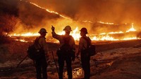 Petugas pemadam kebakaran berjuang pada hari Kamis (9/1/2025), untuk mengendalikan serangkaian kebakaran besar di wilayah Los Angeles. Kebakaran telah menewaskan tujuh orang dan menghanguskan setidaknya 10.000 bangunan dari Pantai Pasifik hingga Pasadena, dan membuat ribuan orang panik meninggalkan rumah mereka. AP/Ethan Swope